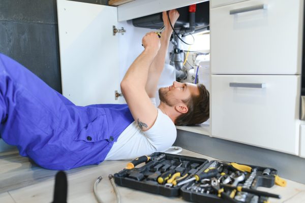 Plumber installs or change water filter. Replacement aqua filter. Repairman installing water filter cartridges in a kitchen. Installation of reverse osmosis water purification system